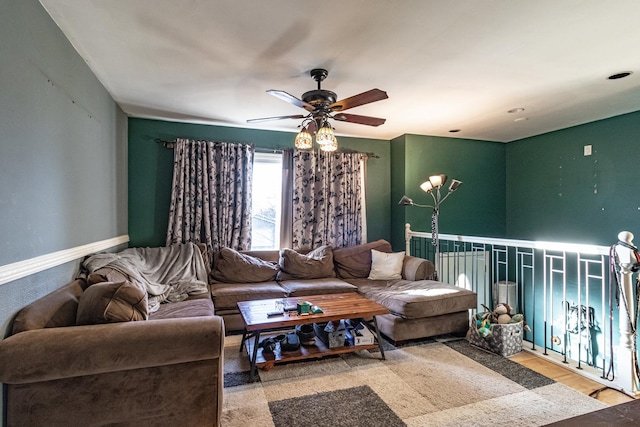 living room with a ceiling fan, baseboards, and wood finished floors