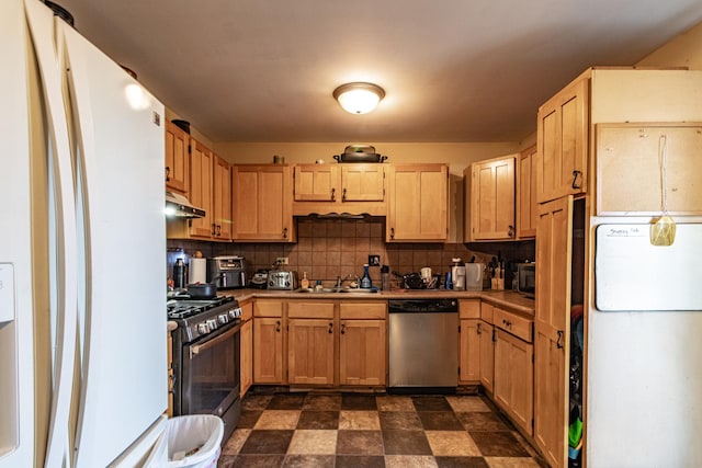 kitchen featuring dishwasher, gas range, freestanding refrigerator, and under cabinet range hood