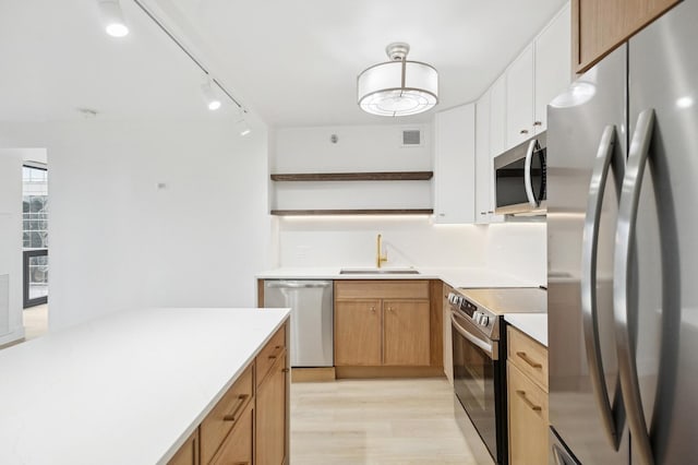 kitchen featuring a sink, visible vents, light countertops, appliances with stainless steel finishes, and open shelves