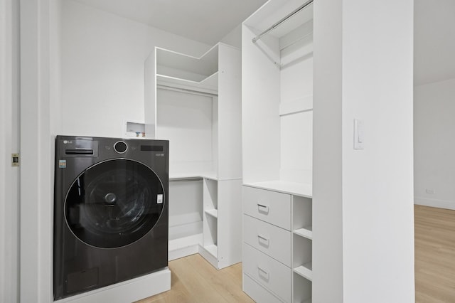 washroom featuring washer / dryer, laundry area, light wood-style floors, and baseboards