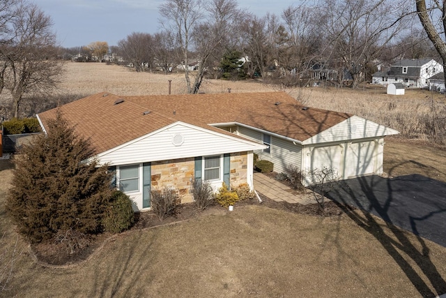 exterior space with aphalt driveway, stone siding, and a shingled roof