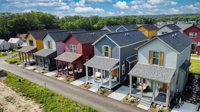 view of front facade featuring a porch, a residential view, and a shingled roof