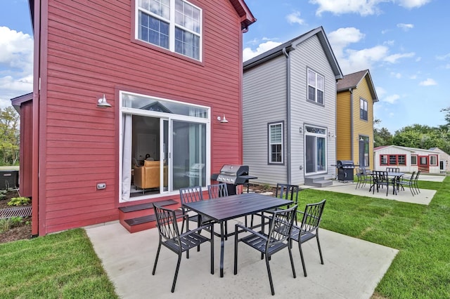 back of property featuring entry steps, outdoor dining area, a patio, and a lawn