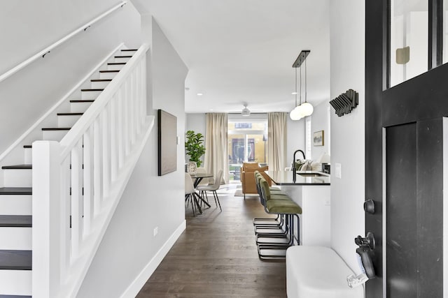 entryway featuring dark wood-type flooring, recessed lighting, stairway, and baseboards