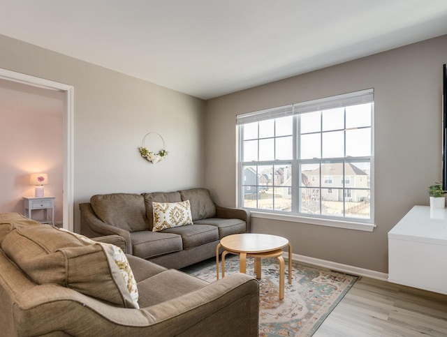 living area featuring baseboards and light wood-style floors