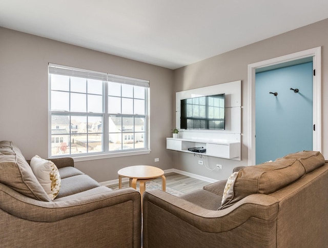 living area featuring baseboards and wood finished floors