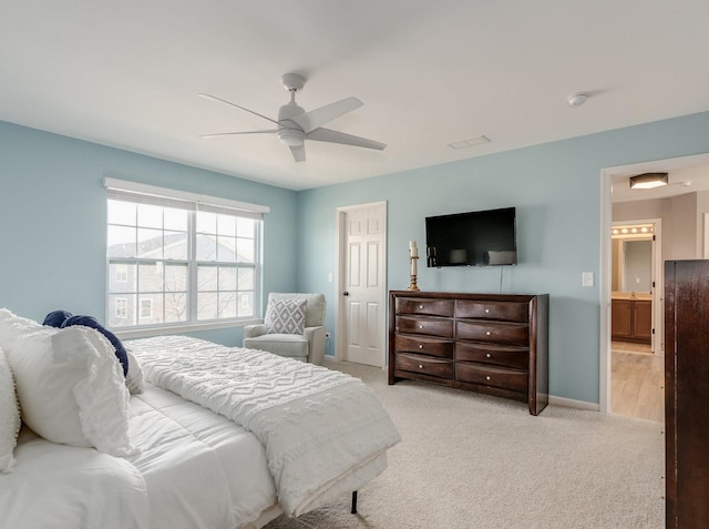 bedroom with a ceiling fan, carpet flooring, baseboards, and ensuite bathroom