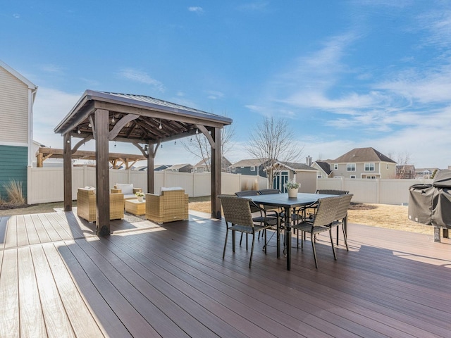 wooden terrace with outdoor dining area, a fenced backyard, outdoor lounge area, and an outdoor structure