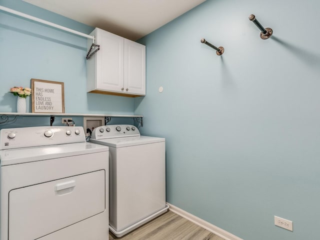 laundry area featuring light wood-type flooring, cabinet space, baseboards, and washer and dryer