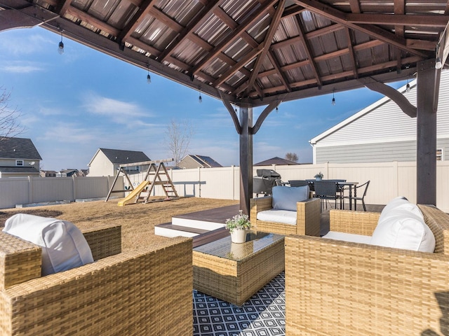 view of patio / terrace featuring a fenced backyard, an outdoor hangout area, outdoor dining area, a gazebo, and a playground