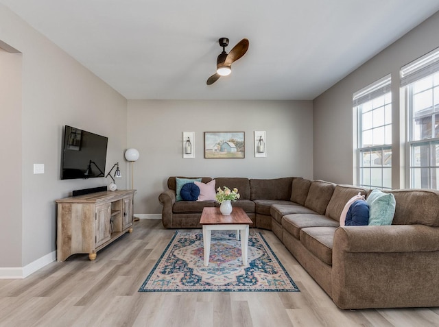 living room featuring ceiling fan, light wood-style flooring, and baseboards