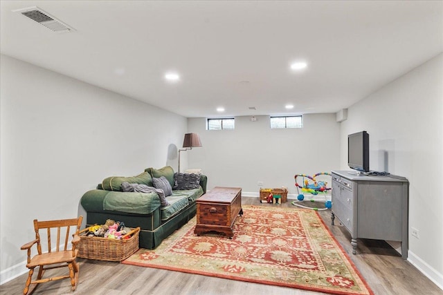 living room with recessed lighting, wood finished floors, visible vents, and baseboards