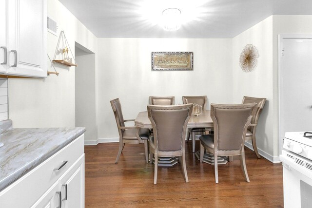 dining space with baseboards, visible vents, and dark wood finished floors