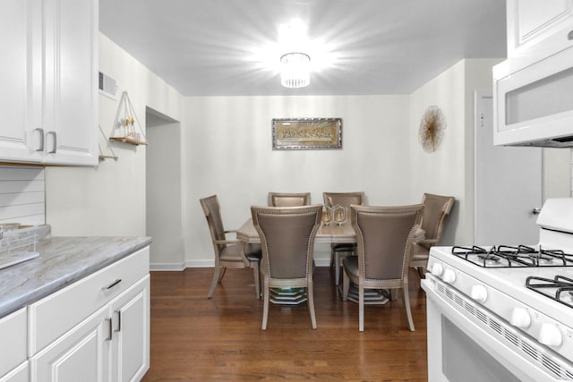dining area featuring dark wood-type flooring, visible vents, and baseboards