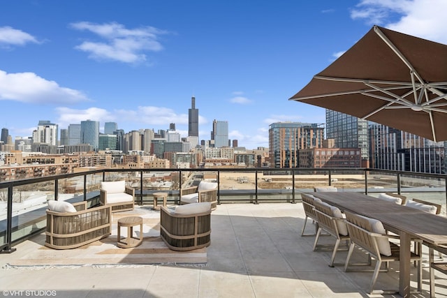 view of patio / terrace featuring a view of city, a balcony, and outdoor lounge area