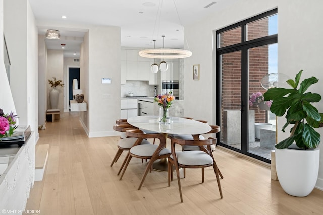 dining area with recessed lighting, light wood-style flooring, and baseboards