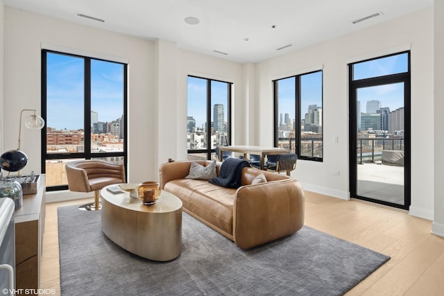 living area featuring a view of city, light wood-style floors, and visible vents