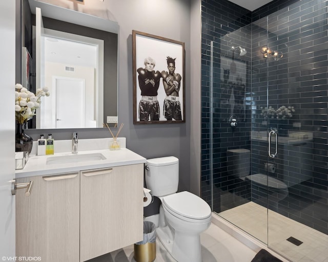 bathroom featuring vanity, toilet, visible vents, and a stall shower