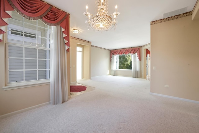 empty room featuring an inviting chandelier, carpet, and baseboards