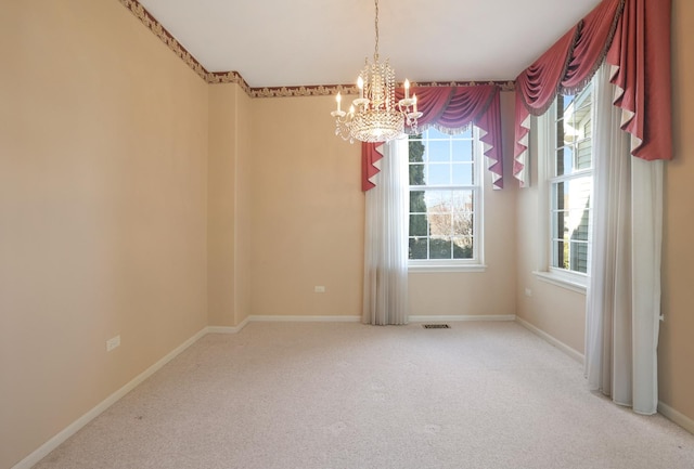 unfurnished room featuring a chandelier, carpet, visible vents, and baseboards