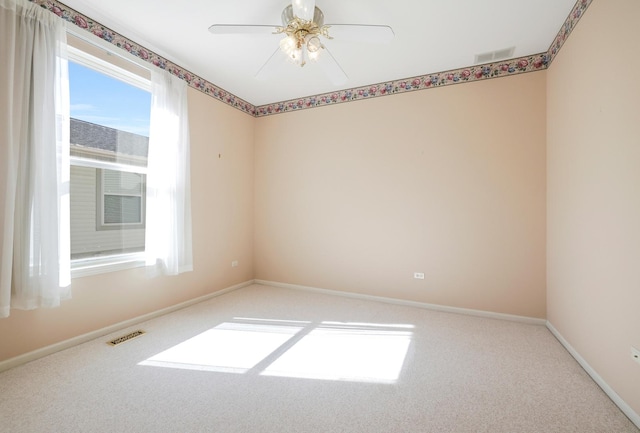 carpeted empty room with a wealth of natural light, visible vents, and baseboards