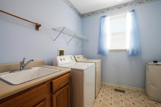 clothes washing area featuring a sink, visible vents, baseboards, independent washer and dryer, and cabinet space