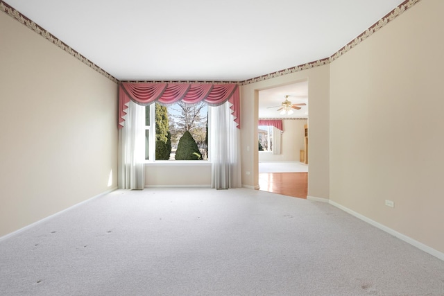 carpeted spare room featuring baseboards