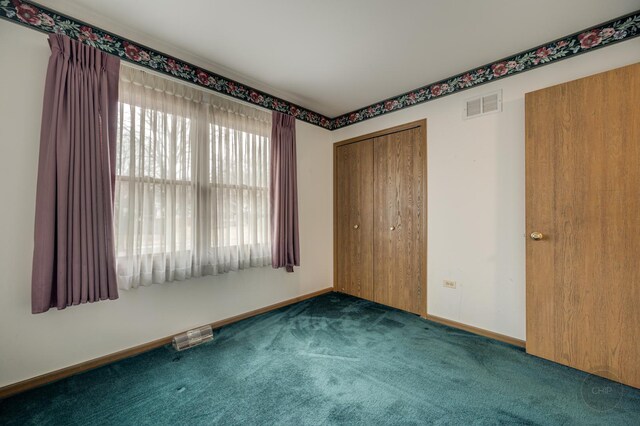 unfurnished bedroom with a closet, baseboards, visible vents, and carpet flooring