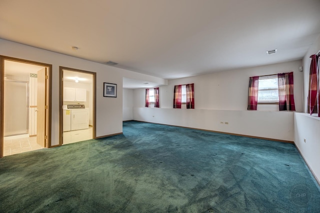 carpeted empty room with baseboards, visible vents, and washer and dryer