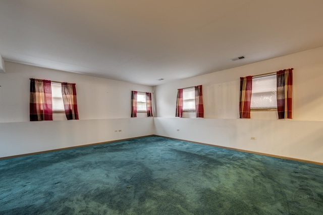 spare room featuring carpet floors, baseboards, and visible vents