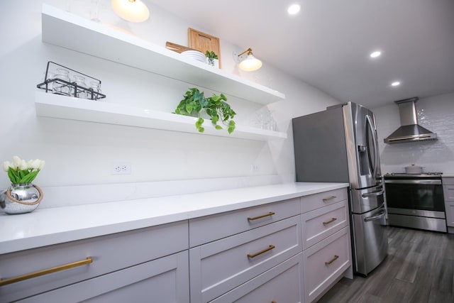 kitchen featuring stainless steel appliances, dark wood-type flooring, light countertops, wall chimney range hood, and open shelves