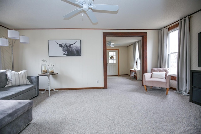 carpeted living room with a ceiling fan, a healthy amount of sunlight, and ornamental molding