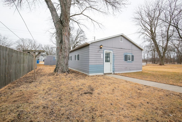 exterior space featuring a yard, an outbuilding, and fence