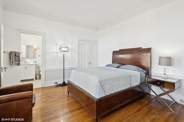 bedroom featuring crown molding, baseboards, and wood finished floors