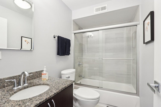 full bath with visible vents, vanity, toilet, and combined bath / shower with glass door