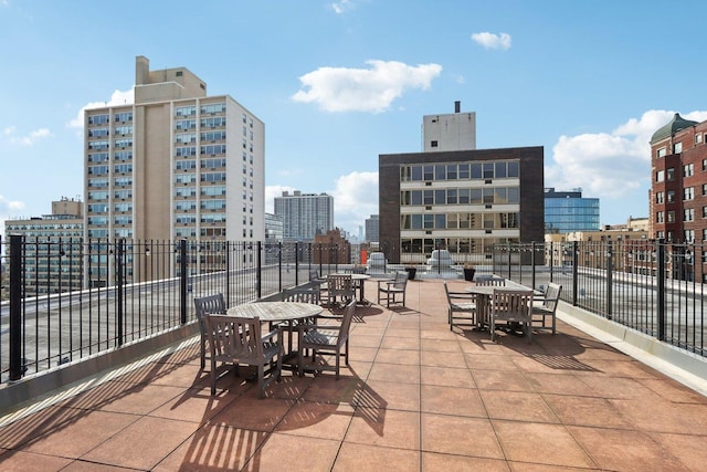 view of patio / terrace featuring a view of city and fence