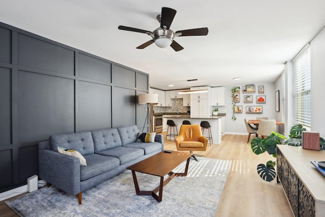 living area with a ceiling fan and light wood finished floors