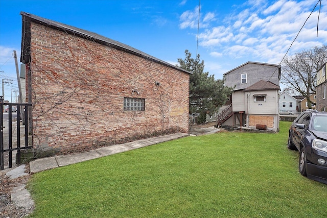 view of home's exterior featuring brick siding and a yard