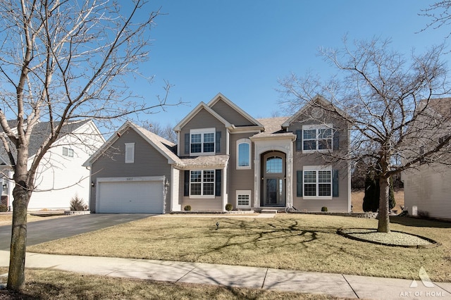 traditional home featuring driveway, an attached garage, and a front yard