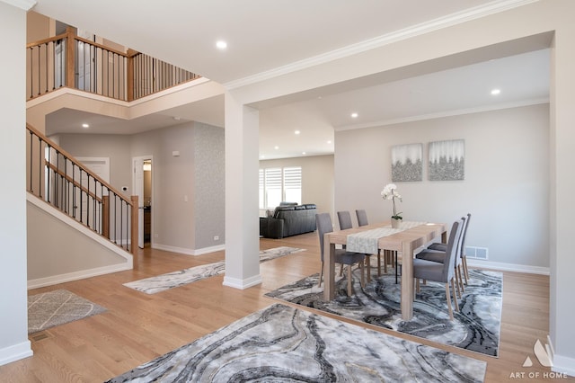 dining room with stairs, crown molding, wood finished floors, and baseboards