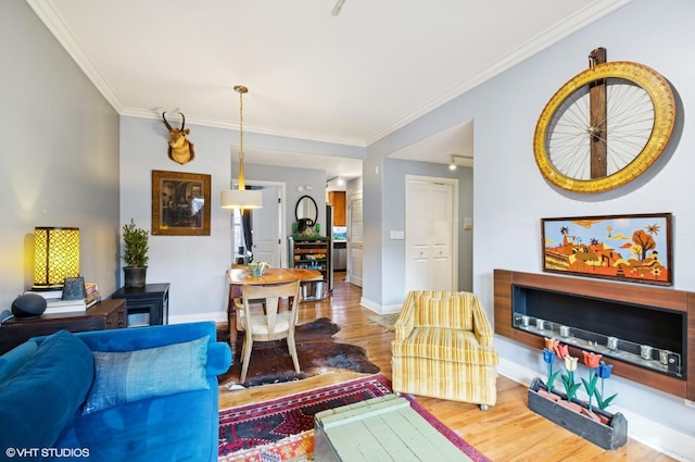 living room with baseboards, a fireplace, ornamental molding, and wood finished floors