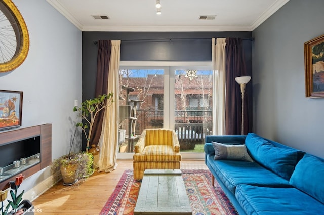 sitting room featuring ornamental molding, visible vents, and wood finished floors