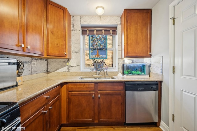 kitchen featuring electric range oven, light stone counters, backsplash, stainless steel dishwasher, and a sink