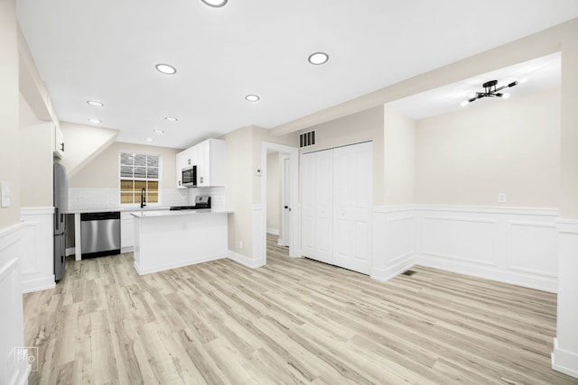 kitchen with visible vents, stainless steel appliances, backsplash, and open floor plan