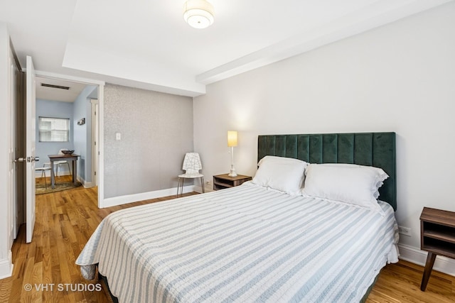 bedroom with baseboards and wood finished floors