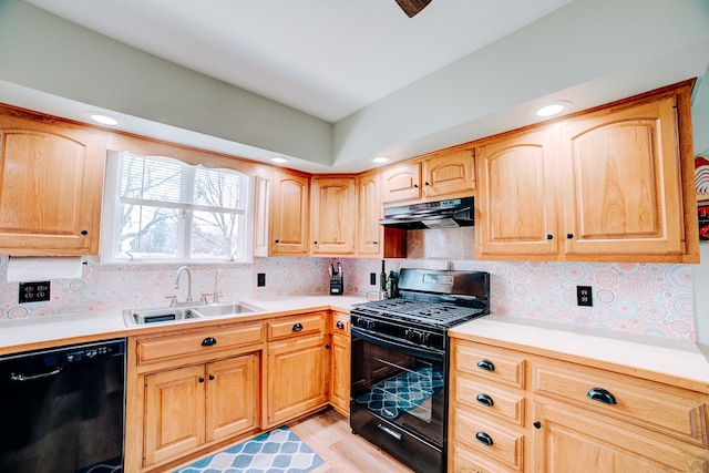 kitchen with under cabinet range hood, black appliances, light countertops, and a sink