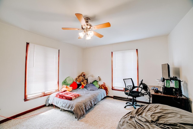 carpeted bedroom featuring baseboards and a ceiling fan