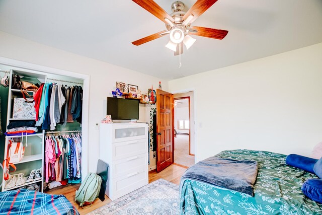bedroom featuring a closet, light wood-style floors, and a ceiling fan