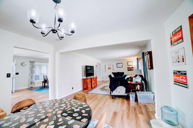interior space with baseboards, an inviting chandelier, and wood finished floors