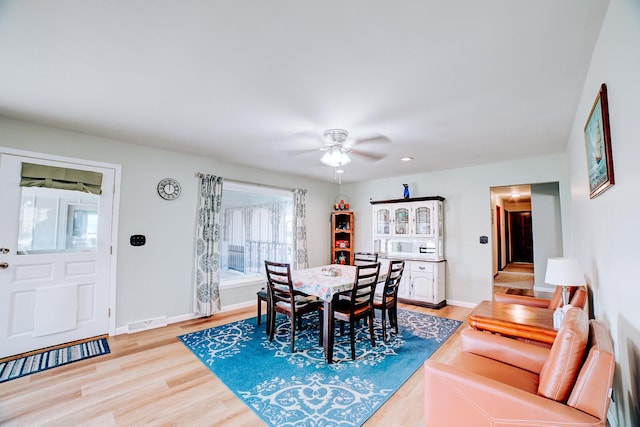 dining area with baseboards, a ceiling fan, visible vents, and light wood-type flooring